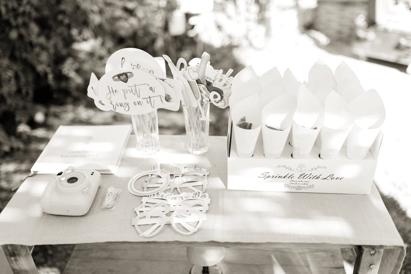 A guest book open on a table with instant prints and a pen beside it