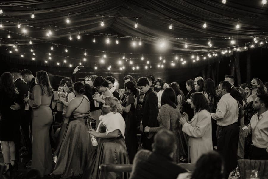 A guest book open on a table beside instant prints and a pen